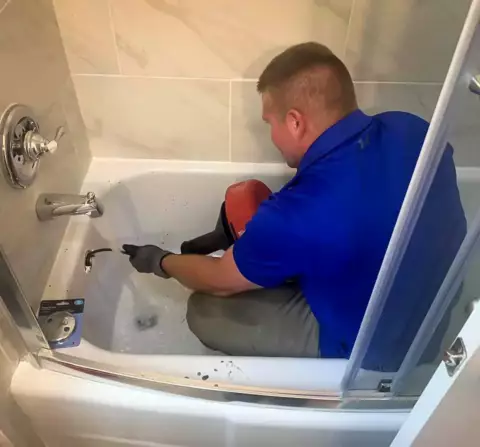 The Magnolia plumbing crew hard at work uinstopping this tub drain.